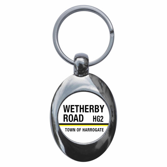 A picture of the front of the product, titled Wetherby Road HG2 Harrogate Road Sign Metal Keyring With Trolley Coin