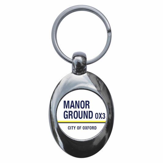 A picture of the front of the product, titled Manor Ground OX3 Oxford Road Sign Metal Keyring With Trolley Coin
