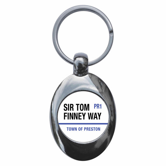 A picture of the front of the product, titled Sir Tom Finney Way PR1 Preston Road Sign Metal Keyring With Trolley Coin
